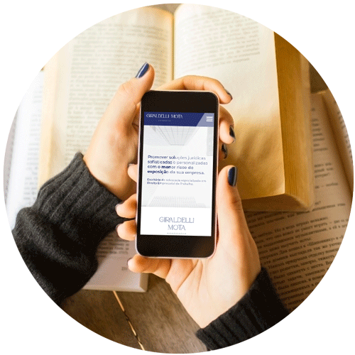 Imagem circular contendo duas mãos segurando um telefone celular.